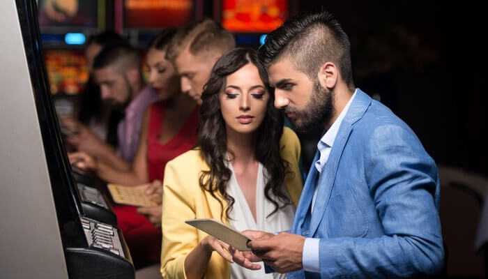 Pirate queen | tycoonstory media Couple playing slot games at a casino, capturing the engaging and social gameplay vibe offered by 96ace singapore.