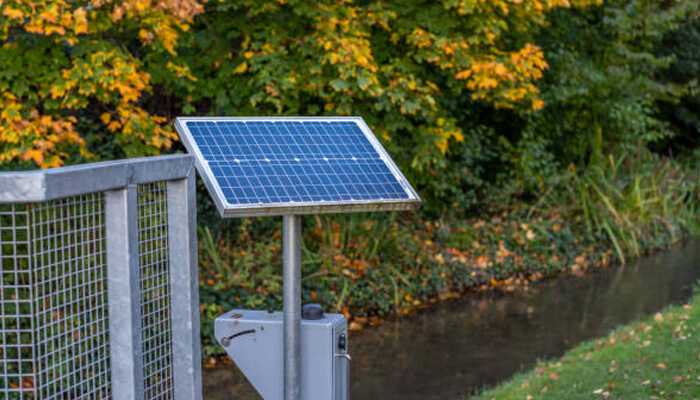 Solar-powered gate openers | tycoonstory media Solar powered gate opener for driveway access, installed near a peaceful garden area, harnessing renewable energy for automated entry.
