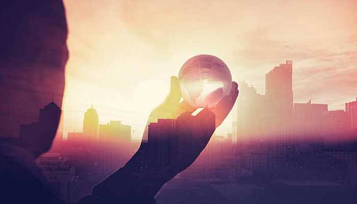 Vision and mission | tycoonstory media A silhouette holding a crystal ball against a glowing cityscape at sunset, symbolizing visionary leadership and future insights, inspired by fawad malik.