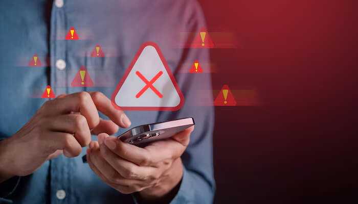 Warning signs of smartphone addiction | tycoonstory media Smartphone addiction: a person holding a phone with warning signs and error alerts indicating issues related to excessive phone use.