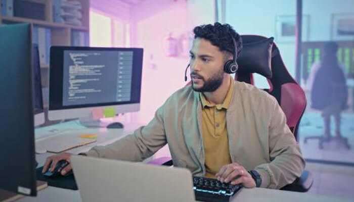 What is data analytics in call centers 1 | tycoonstory media Call center agent using data analytics in call centers to provide customer support while working with dual monitors and a headset.