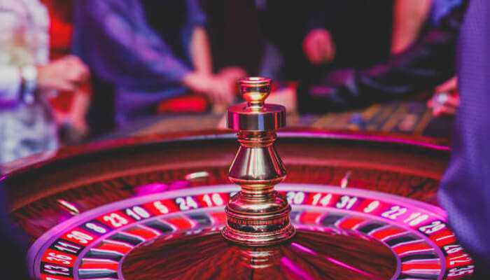 Are free credit offers legit | tycoonstory media Spinning roulette wheel under colorful lights at a free credit casino game night.