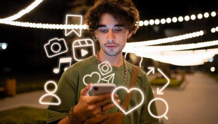 Creating for engagement 1 | tycoonstory media Young man engaging with tiktok on his smartphone, surrounded by interactive social media icons in a vibrant nighttime setting.