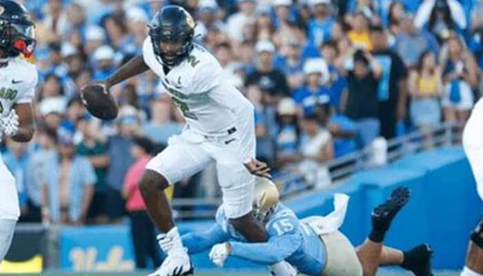 Early life and football beginnings 1 | tycoonstory media Shedeur sanders net worth: shedeur sanders evades a tackle during a college football game, showcasing his athleticism and skill.