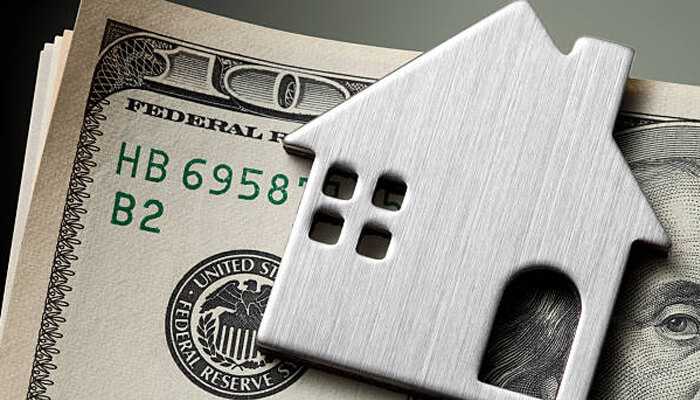 Efficient rent collection and money handling 1 | tycoonstory media A house-shaped cutout placed on u. S. Dollar bills, representing the financial advantages when you hire a property manager to protect your investment.