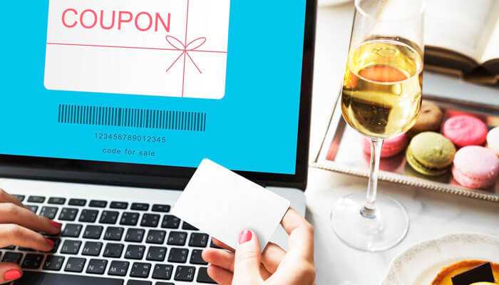 Gc coupons mobile app savings in your pocket - tycoonstory | tycoonstory media User applying gc coupons during online checkout on a laptop, with wine and macarons in the background for a cozy shopping experience.