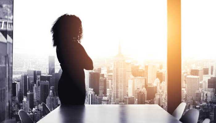 Real estate investments | tycoonstory media A silhouette of a businesswoman looking out over a city skyline, symbolizing ambition, wealth, and empowerment, related to tracey edmonds net worth journey.