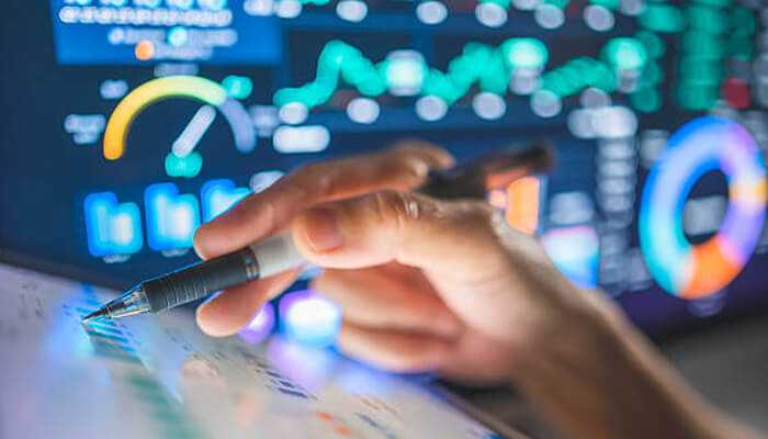 Real-time data | tycoonstory media Hand using a stylus on a digital screen displaying complex analytics and data graphs, representing the efficiency and data-driven capabilities of cloud payroll software.