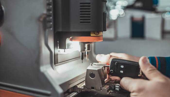 Services that go beyond unlocking doors | tycoonstory media Technician providing car key services by repairing a vehicle's ignition system to resolve key and lock issues efficiently.