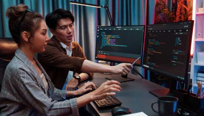 Skills that make full stack developers valuable | tycoonstory media Team collaboration in a coding session, showing why companies hire full stack developers to manage complex software development tasks.