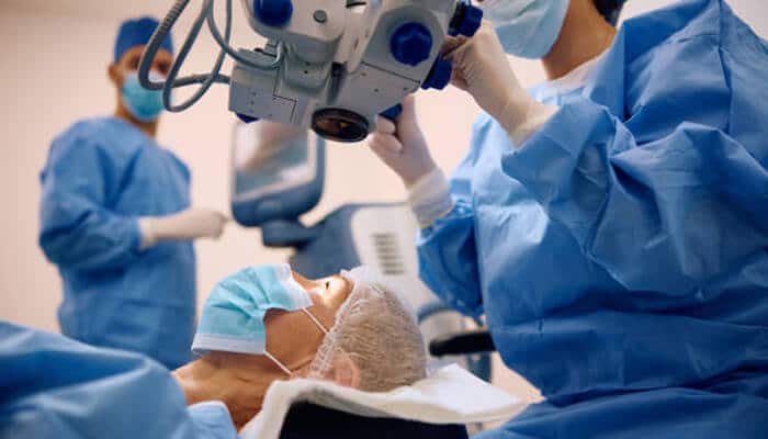 Step-by-step procedure of eye surgery | tycoonstory media A patient undergoing cataract eye surgery with medical staff operating advanced ophthalmic equipment in a sterile surgical environment.