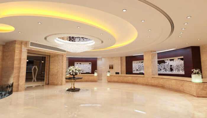 Where youll find them | tycoonstory media Spacious hotel lobby with polished beige floors and a striking circular ceiling design, offering a sleek, modern welcome in a refined setting.