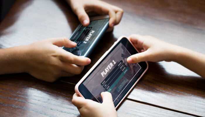 Why are gamers turning to mobile | tycoonstory media Two players engaged in a competitive mobile gaming session on smartphones, showcasing multiplayer interaction.