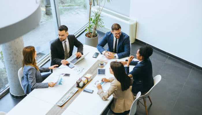 Why general leadership training falls short | tycoonstory media Leadership team engaged in a strategic discussion, highlighting teamwork and executive decision-making in a corporate setting.