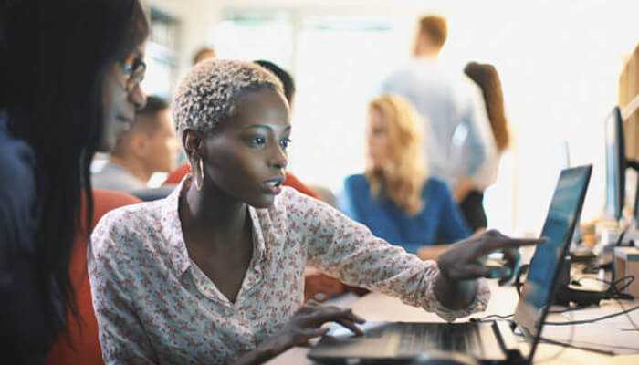 Zycus procure-to-pay software 1 | tycoonstory media Business professionals collaborating on roi of digital procurement solutions using laptops in a modern office environment.