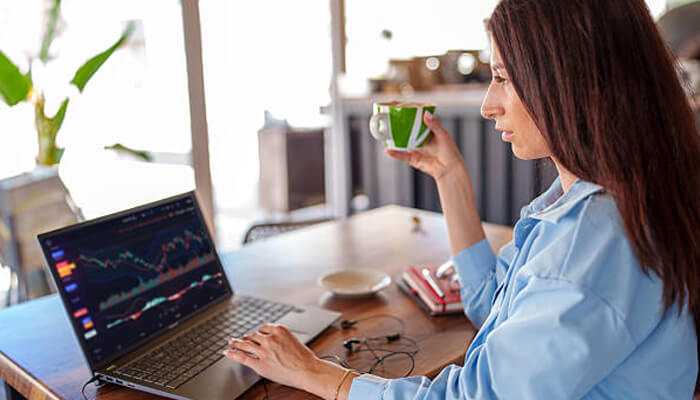 Financial planning for digital nomads Remote professional reviewing financial charts on a laptop while working from home, highlighting smart financial planning for digital nomads and online investing.