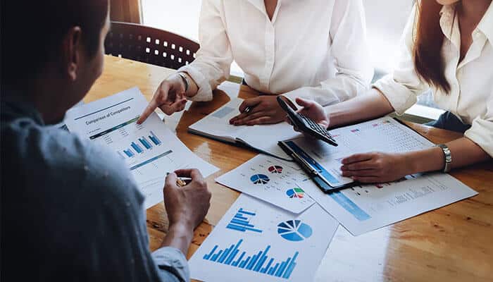 Involving key stakeholders in budget planning - tycoonstory | tycoonstory media Business relocation planning meeting with charts, graphs, and financial documents on a table.