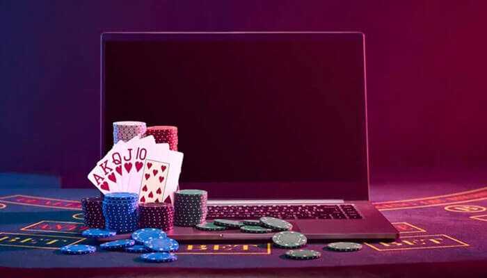 Issues with cross-border jurisdiction - tycoonstory | tycoonstory media Laptop with playing cards and poker chips showcasing the growing trend of online gambling in virtual casinos.