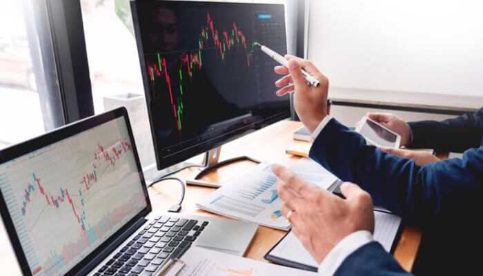 Trading tools and platforms Person analyzing market charts on a laptop using essential trading tools and platforms for beginners.