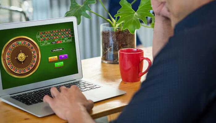 Keep track of your activity - tycoonstory | tycoonstory media Man using a laptop to play an online roulette game, highlighting the popularity of online casino malaysia platforms.