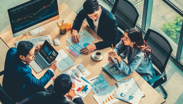 Crypto solutions for fintech projects Team analyzing financial charts and discussing crypto solutions for fintech projects in a meeting room.