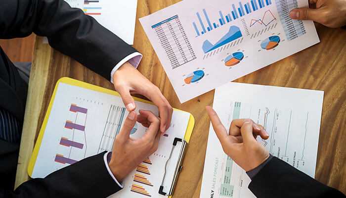 Financial implications post-arrangement - tycoonstory | tycoonstory media Team reviewing company financial charts and documents as part of a company voluntary arrangement plan.