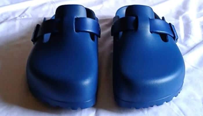 Footwear cleaning hack Pair of blue birkenstock eva clogs placed on a white surface — footwear cleaning hack for easy-to-wash waterproof shoes.