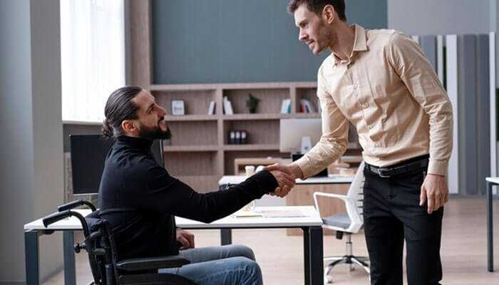 The importance of substantial gainful activity in determining eligibility - tycoonstory | tycoonstory media Man in wheelchair discussing social security disability benefits with advisor in office