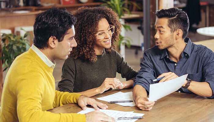 The role of professional guidance - tycoonstory | tycoonstory media Financial advisor discussing debt relief and credit score options with clients.