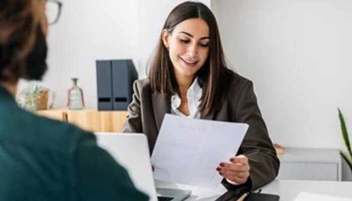 Mental ability test A candidate smiling during an interview while reviewing a document, showcasing the importance of mental ability tests in the hiring process.