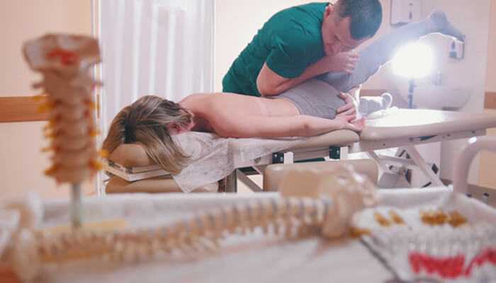 Chiropractic wellness in ocoee A chiropractor performing a therapeutic adjustment on a patient lying on a treatment table, representing professional care and holistic healing through chiropractic wellness in ocoee.