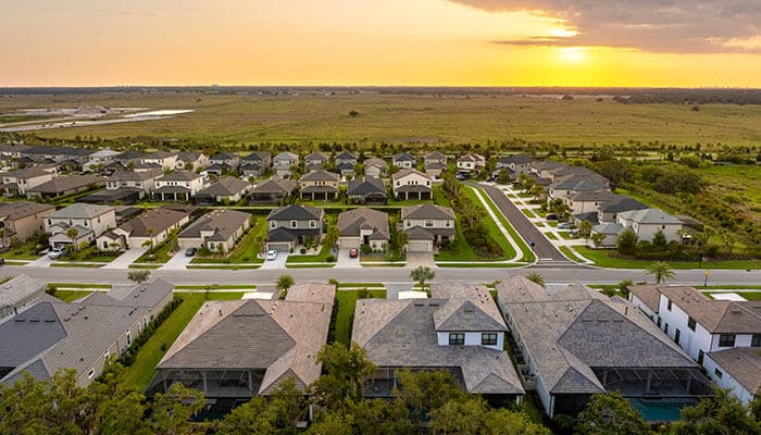 Climate and comfort considerations - tycoonstory | tycoonstory media Housing market in australia shown through aerial view of suburban residential neighborhood at sunset.