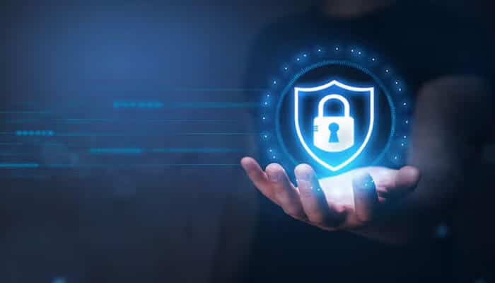 Indirect and intangible costs - tycoonstory | tycoonstory media Businessman holding a digital security lock icon, symbolizing trust and data protection through a resilience strategy.