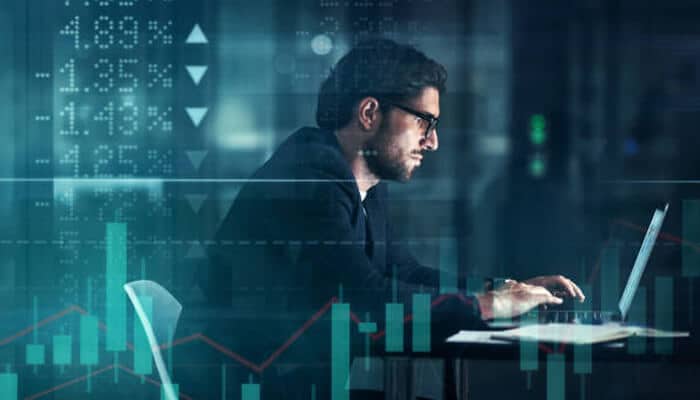 Jp conte's Parkinson's Research A focused professional working on a laptop surrounded by digital financial data and graphs, symbolizing analytical innovation and investment strategies supporting jp conte's Parkinson's research.