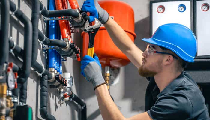 Shifting perspectives - tycoonstory | tycoonstory media Technician performing maintenance on plumbing in hvac system to ensure optimal performance and safety.