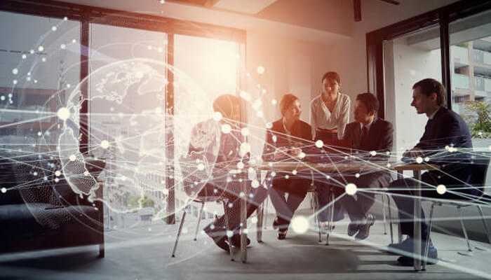 Thought leadership Business team collaborating in a modern office with digital global network graphics overlay, symbolizing leadership and innovation in a connected world.
