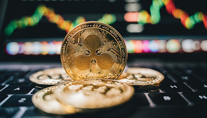 Is cropty wallet right for you | tycoonstory media Physical xrp coins placed on a laptop keyboard with trading chart in the background, showcasing cryptocurrency investment.