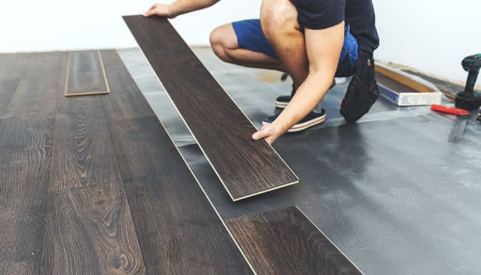 Load distribution and structural concerns - tycoonstory | tycoonstory media Professional installing durable commercial floors with dark wood finish, emphasizing strength and long-lasting performance.