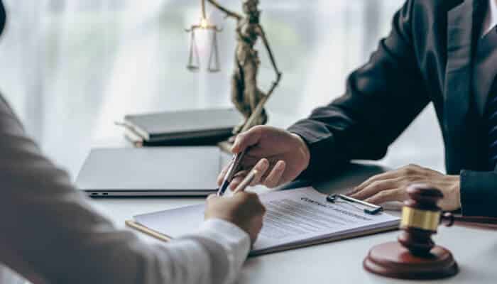 Pay attention to communication and accessibility 1 | tycoonstory media Jackknife accident lawyer consulting with a client, discussing legal documents related to an accident case.