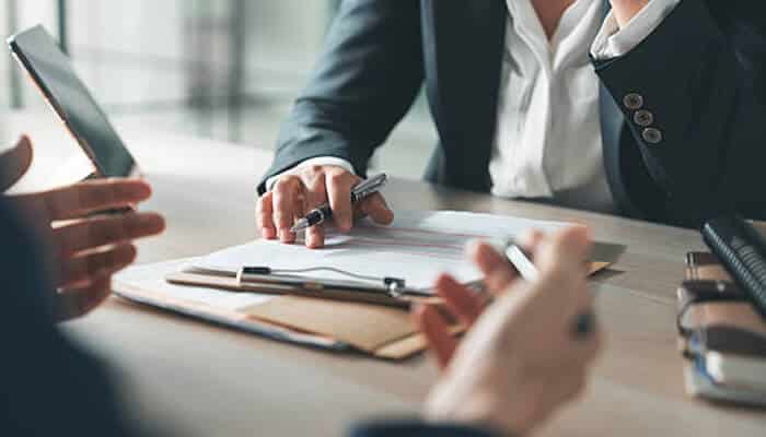 Investment property loans A business meeting where individuals review documents and discuss financial options, representing professional guidance related to investment property loans.