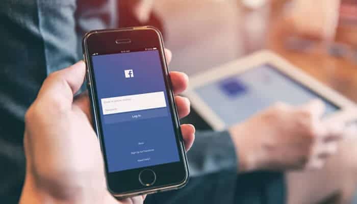 Strengthen account security - tycoonstory | tycoonstory media User logging into the facebook app on a smartphone, symbolizing secure access and control over facebook profile visibility settings.