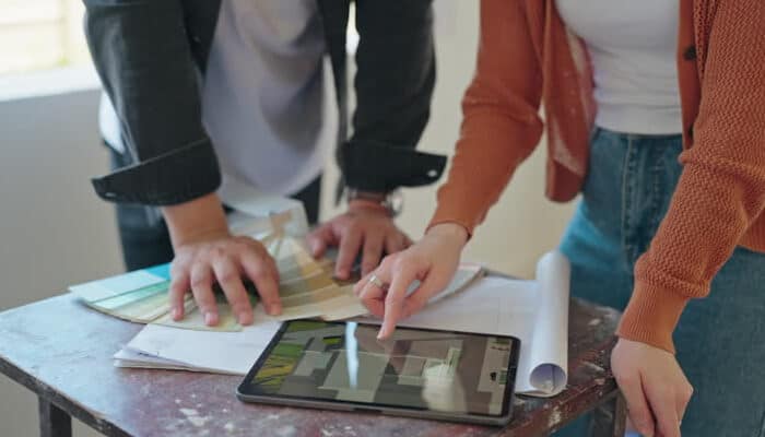 Remodeling company A couple reviewing home renovation plans on a tablet, discussing design choices and materials as part of their consultation with a remodeling company.