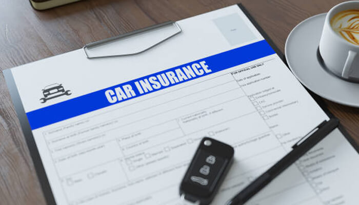 What to do if your car insurance policy has lapsed 1 | tycoonstory media Close-up of a car insurance application form with a car key and pen, symbolizing the convenience of purchasing car insurance online.