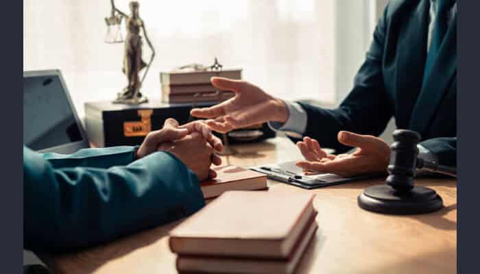 Olen firm Attorney meeting with a client at a desk with legal books and a gavel, representing olen firm legal services.