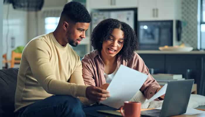 Lessons from early-stage growth and why founders benefit from outside perspective | tycoonstory media A couple discussing financial paperwork with a laptop at home, representing personal investment decisions involving private debt funds.