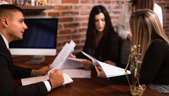 Bailey & burke A group of professionals reviewing documents around a wooden desk in a law office, symbolizing a consultation setting similar to services offered by bailey & burke.