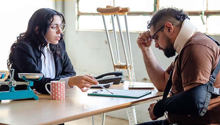 Motorcycle accident claims An injured man meeting with a professional to review paperwork, symbolizing the guidance and documentation often involved in motorcycle accident claims.