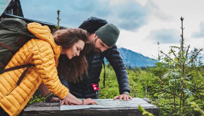 Seasonal travel comparison | tycoonstory media Hikers studying a map during a bhutan and nepal trip, exploring scenic mountain landscapes together.