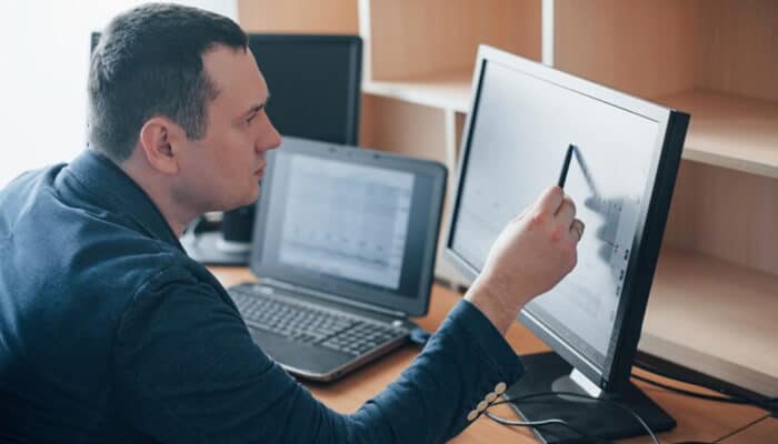 How leverage changes maintenance and oversight | tycoonstory media A professional analyzing data on a computer screen, demonstrating how leverage amplifies risk by making small changes more impactful in a high-stakes environment.