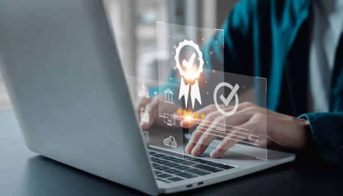 How to choose the right certification | tycoonstory media A person typing on a laptop with holographic icons related to certifications and achievements, emphasizing the importance of choosing the best it certification for career advancement.